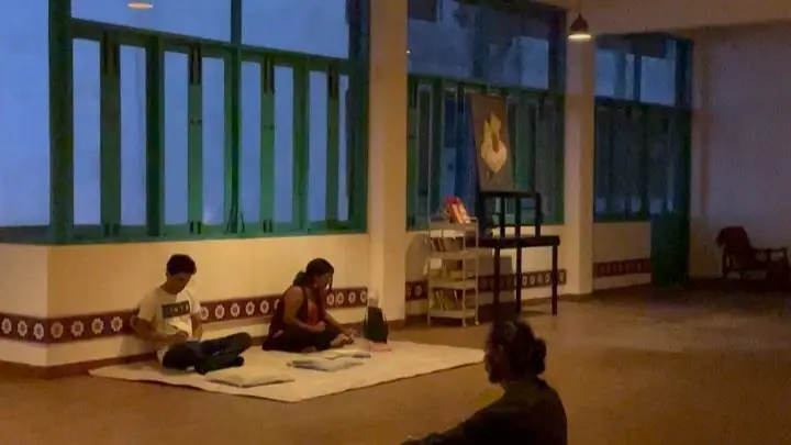 People sitting on mats painting together in the space