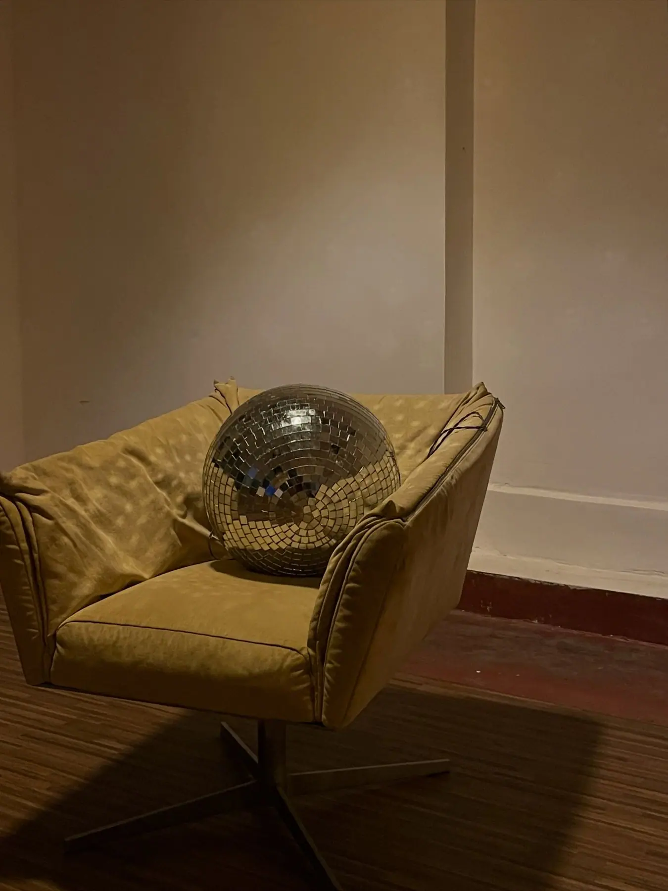 A mirror ball resting on an armchair