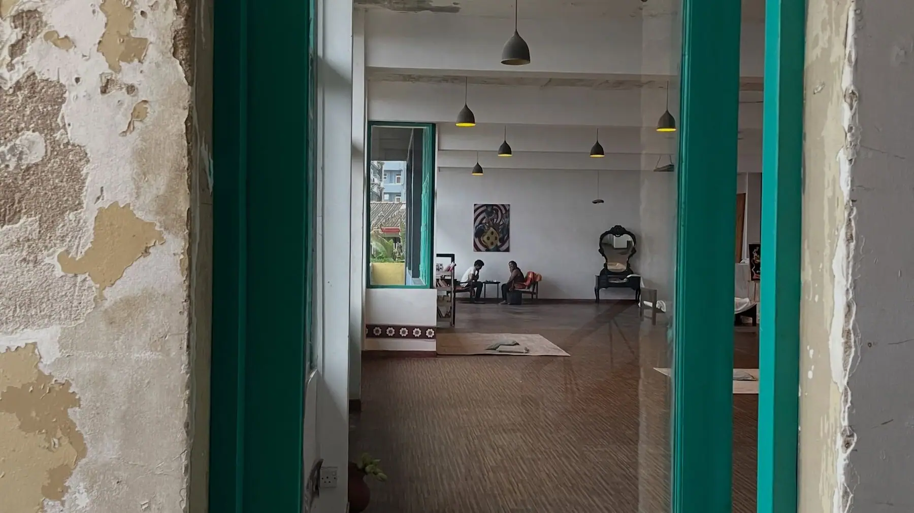 Looking into the gallery through teal window frames