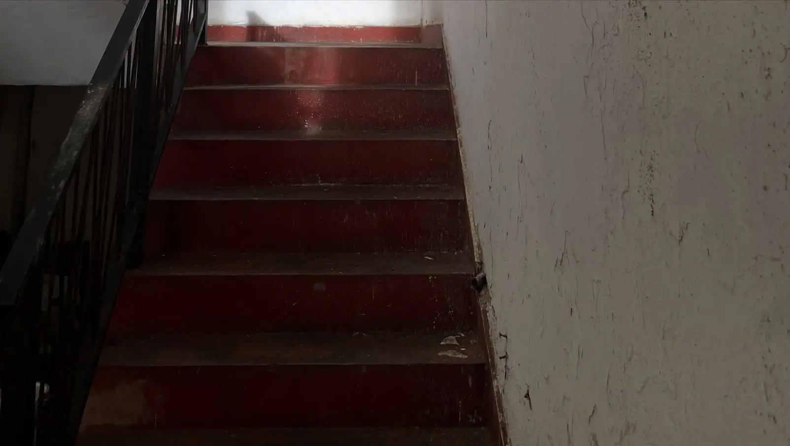 A red staircase rising to the light