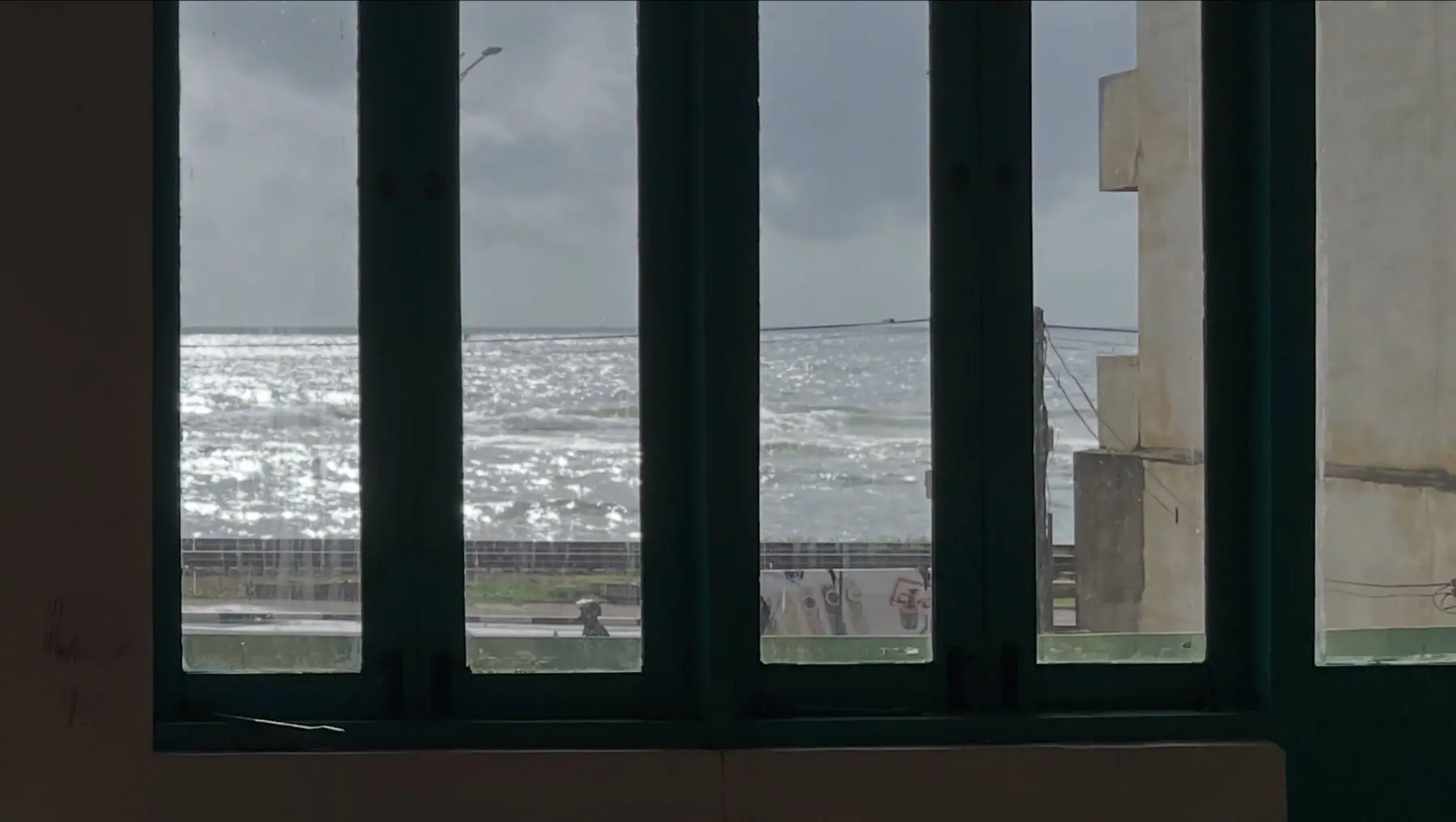 Teal-framed windows looking out over the sea