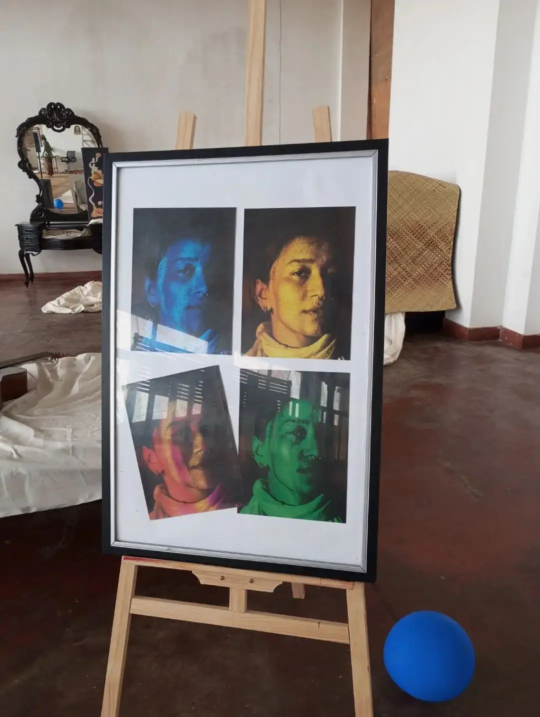 Four colour-lit portraits in a frame on an easel
