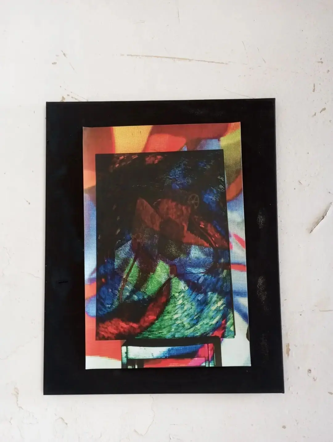 A framed colour work on a white wall