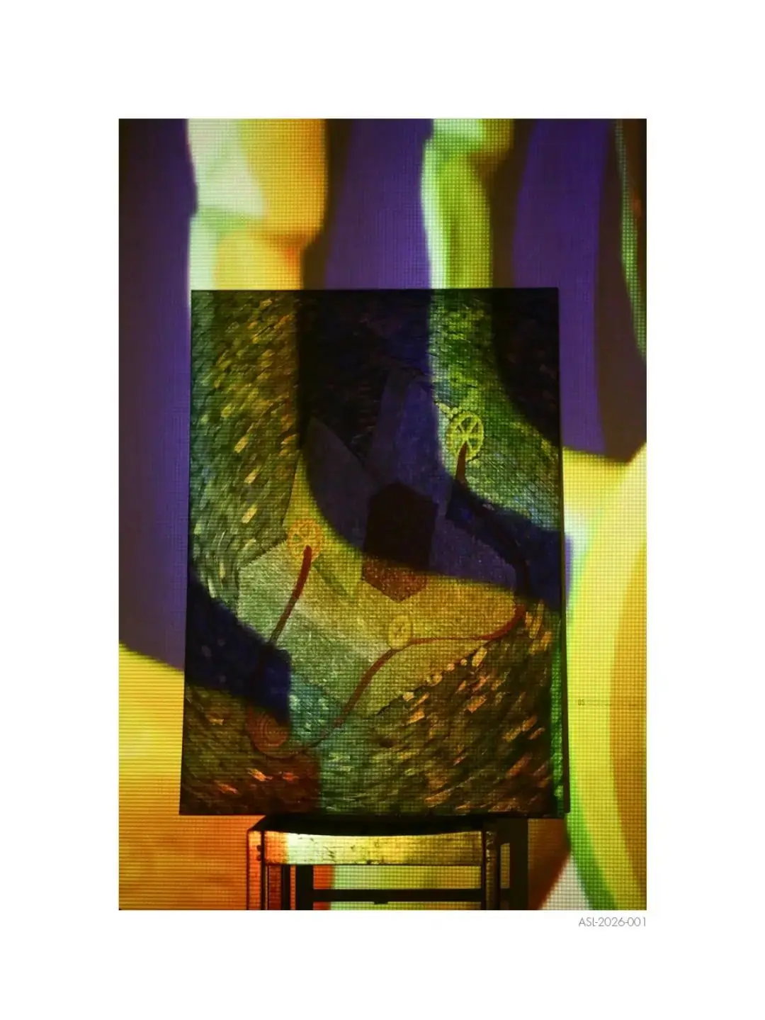 A painting on a stool with coloured light projected across it